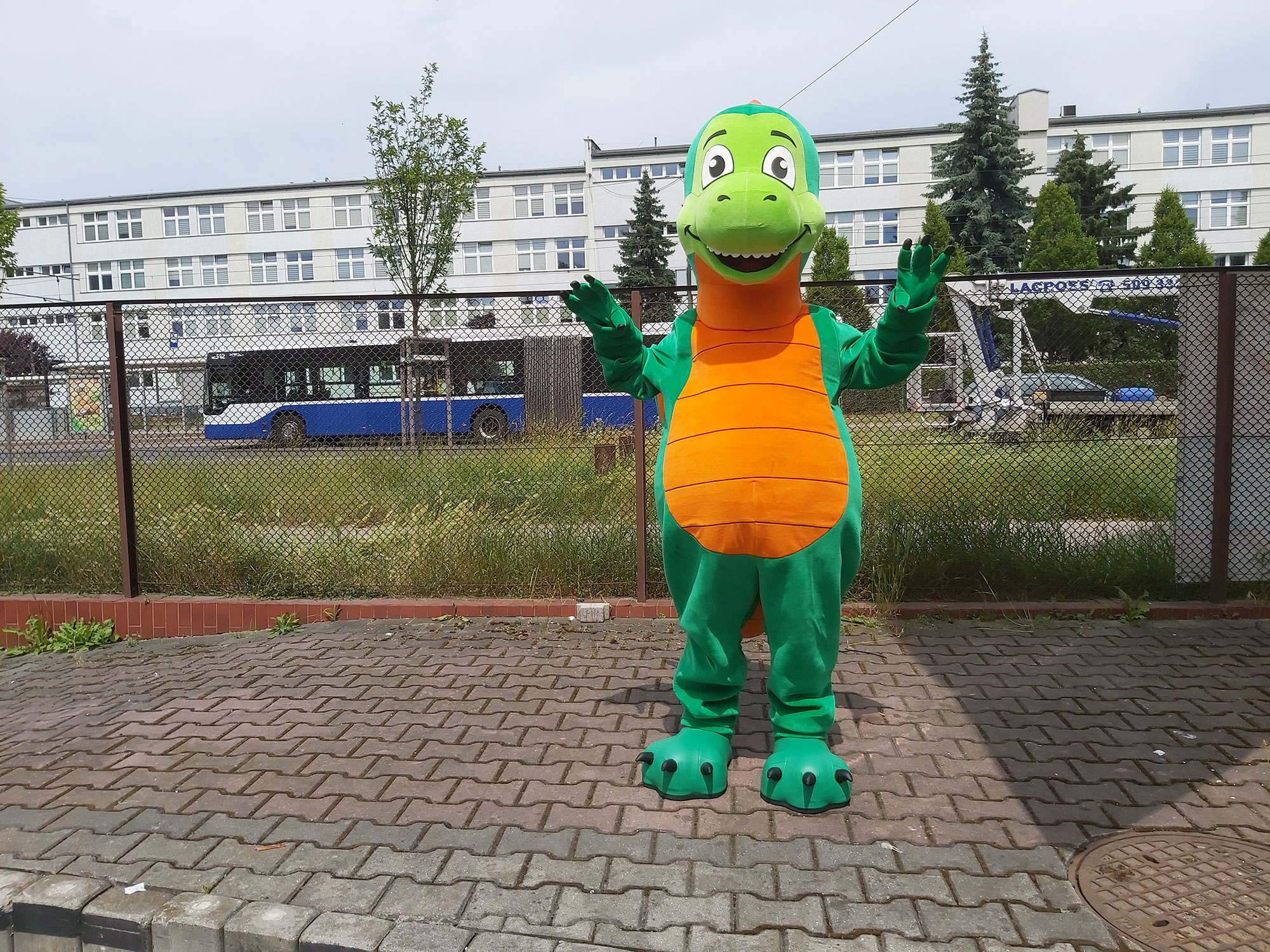 Kostium reklamowy w postaci smoka pozuje do fotografii opodal siedziby firmy Elabika